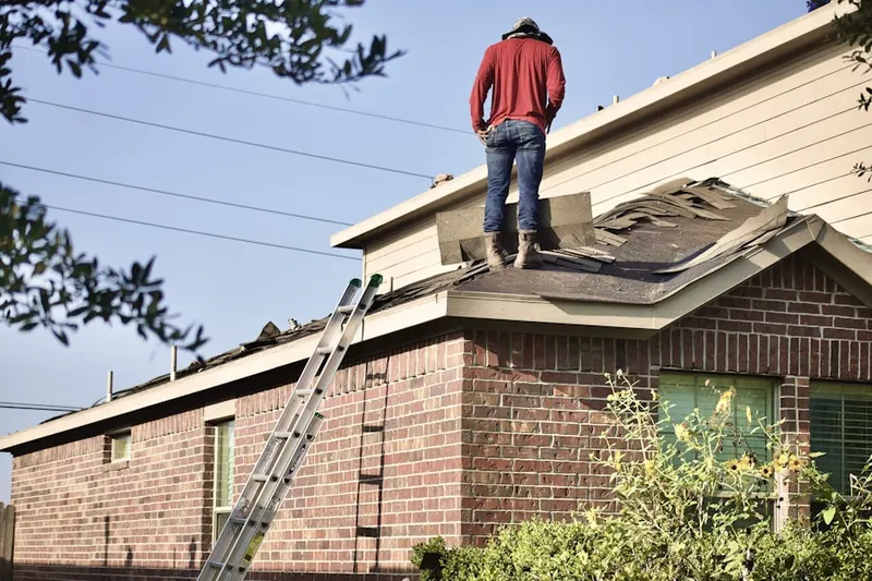 Professional roofer working on a residential roof in Las Flores